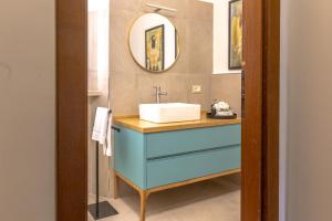 a bathroom with a blue sink and a mirror at Altobelli Apartment in Rieti +58 photos
