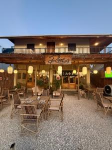 a restaurant with wooden tables and chairs in front of a building at Roots inn in Paje