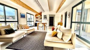 a living room with two couches and a table at Au pied du port, 150m2 - Parking gratuit, Climatisation, Terrasses - Standing in Bonifacio