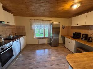 a kitchen with a refrigerator and a window at Männi Farm Holiday House in Eoste