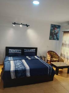 een slaapkamer met een bed en een stoel bij Short Let Apartments in Lagos Business School Lekki Ajah in Lekki