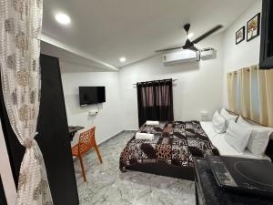a bedroom with a bed and a desk and a tv at Eva Beach Side Room in Mandrem