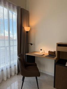 a desk with a lamp and a chair next to a window at Booze room in Ban Khlong Chi Lat
