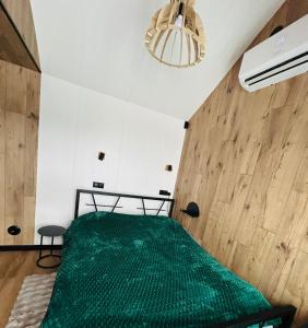 een slaapkamer met een groen bed in een kamer bij Domek Jak z Obrazka in Sierpnica