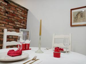een tafel met witte borden en wijnglazen erop bij Sava & Double Rooms in Prijedor