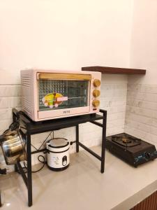 a microwave on a stand on a kitchen counter at Villa Dino Park Batu in Karangploso +19 photos
