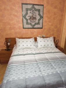 a bed with white pillows and a picture on the wall at Casa el Alfar mudéjar in Teruel