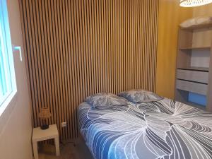 een slaapkamer met een bed met een gestreepte muur bij Casa Sierra -Etretat in Sainte-Marie-au-Bosc