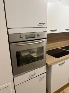 a stainless steel oven in a white kitchen at Appartement 6 personnes avec jacuzzi in Torcy