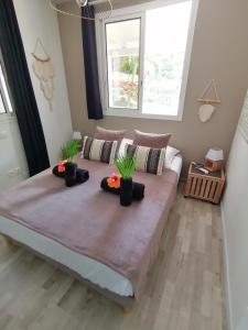 a large bed in a room with two plants on it at Lodge Eden Caraibes 6p avec piscine privée 6x3 in Sainte-Anne +23 photos