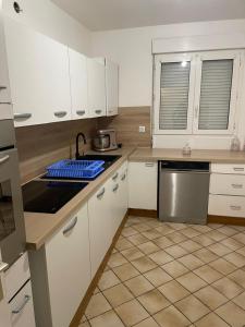 a kitchen with white cabinets and a counter top at Appartement 6 personnes avec jacuzzi in Torcy +8 photos