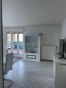 a white living room with a tv and a desk at Appartement 6 personnes avec jacuzzi in Torcy