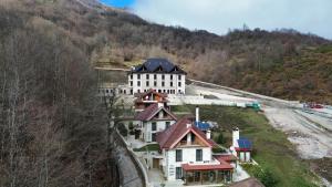 a large white building on the side of a mountain at JOEN Village in Librazhd