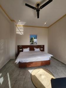 a bedroom with a large bed with a ceiling fan at Himora Bir in Bīr
