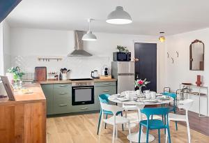 a kitchen with a table and chairs in a kitchen at Charme alsacien avec piscine, proche Strasbourg et Grand Ried in Nordhouse