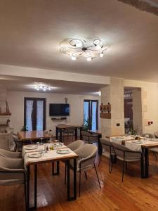 a dining room with tables and chairs and a chandelier at JOEN Village in Librazhd
