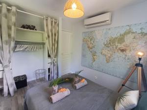a room with two pillows on a bed with a map at Lodge Eden Caraibes 6p avec piscine privée 6x3 in Sainte-Anne