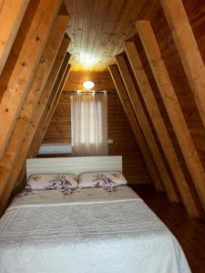 una camera con letto in una mansarda in legno di Sea View Wooden Houses a Lezhë (Alessio)