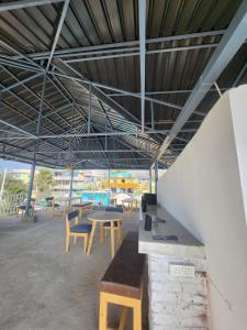 a group of tables and chairs under a roof at Himora Bir in Bīr