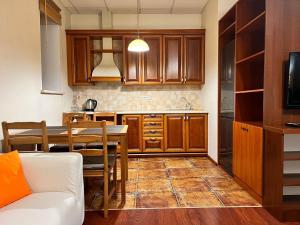 a kitchen with wooden cabinets and a dining table at Holiday Studio in Kozin