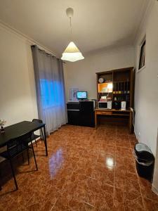 an empty living room with a table and a desk at spacious guest rooms in Lisbon