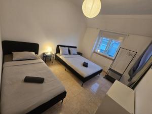 a small room with two beds and a window at spacious guest rooms in Lisbon