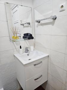 a white bathroom with a sink and a mirror at spacious guest rooms in Lisbon +74 photos