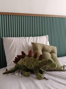 a dinosaur stuffed animal laying on a bed at Villa Dino Park Batu in Karangploso