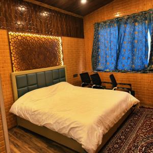 a bedroom with a bed and two chairs in it at Id villa cottage in Tangmarg