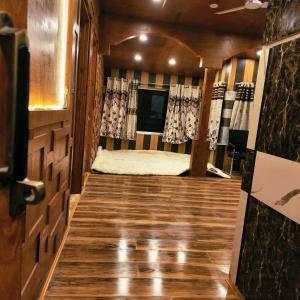 a room with a bed in a room with wooden floors at Id villa cottage in Tangmarg
