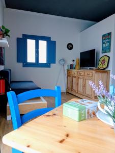 a dining room with a wooden table and blue chairs at Jazz House in Solanas