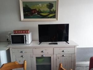 a tv on top of a dresser with a microwave at Charmant studio in Le Tholy