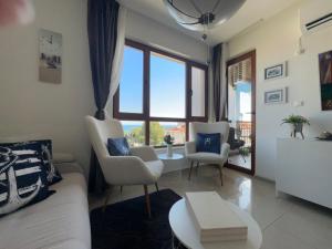 een woonkamer met een bank, stoelen en een tafel bij Paradise Bay D8 Apartment in Sozopol