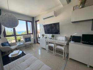 een woonkamer met een witte bank en een tafel bij Paradise Bay D8 Apartment in Sozopol +67 foto's