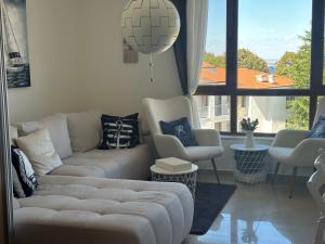 een woonkamer met een bank en een groot raam bij Paradise Bay D8 Apartment in Sozopol