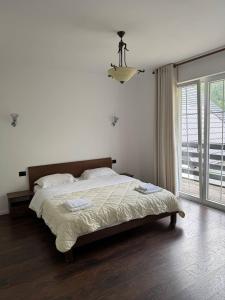 a bedroom with a bed and a large window at Sunhouse Valbone in Valbonë