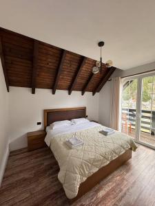 a bedroom with a large bed and a large window at Sunhouse Valbone in Valbonë