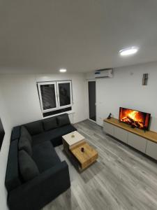 un soggiorno con divano nero e camino di Apartman Prijedor a Prijedor