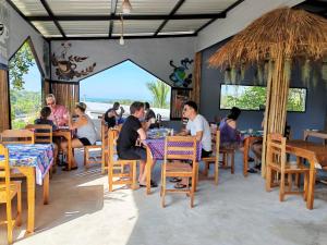 a group of people sitting at tables in a restaurant at Phulanta Resort in Ko Lanta