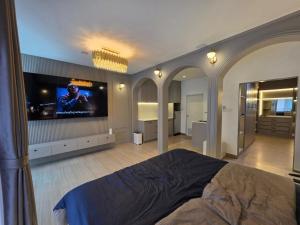 a bedroom with a bed and a flat screen tv at Rarin jinda RESIDENCE in Suratthani