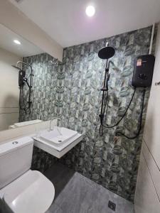a bathroom with a toilet and a sink and a shower at Rarin jinda RESIDENCE in Suratthani