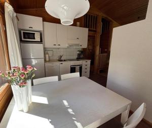 a kitchen with a table with a vase of flowers on it at Loma-aika in Vierumäki