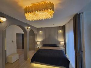 a bedroom with a bed and a chandelier at Rarin jinda RESIDENCE in Suratthani