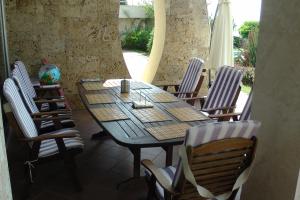 Une table et des chaises en bois sont disponibles sur la terrasse. dans l'établissement Budzhaka Villa, à Sozopol