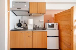 a small kitchen with a microwave and a refrigerator at ライズ201 in Kasugai