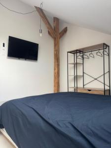 a bedroom with a bed and a cross on the wall at Le gîte de L Échappée Alsacienne in Geispolsheim