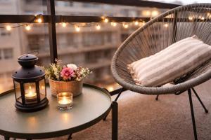 a table with a candle and a chair with a pillow and flowers at Studio Fifty9 in Knokke-Heist +3 photos