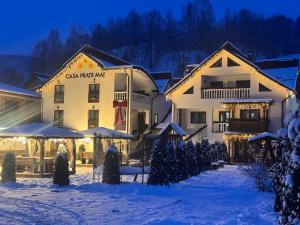 a building with christmas lights in the snow at CASA Fratii MÂT in Moisei
