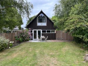 a house with a wooden fence and a yard at De Tuinkamer in Ouddorp +6 photos