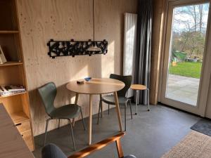 a table and chairs in a room with a window at De Tuinkamer in Ouddorp